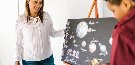 Teacher looking at a student's solar system diagram